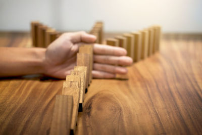 Cropped hand playing with wooden blocks on table