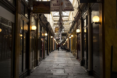 Illuminated street amidst buildings in city at night