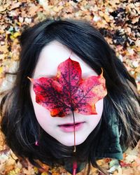 Close-up of girl with autumn leaves