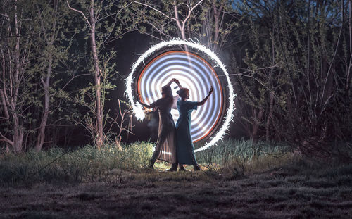 Full length of woman standing on field in forest