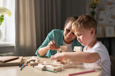 Glad woman and boy playing together