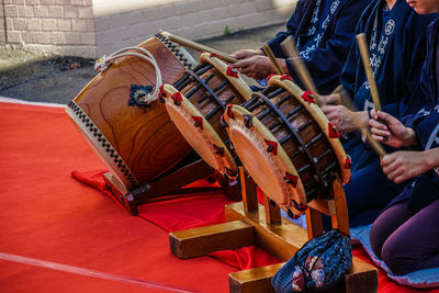 Midsection of people playing musical instruments outdoors