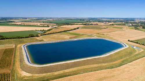 Aerial view of agricultural field against blue sky