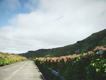 Road by mountain against sky