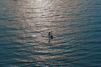 High angle view of silhouette man by sea