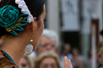 Side view of young woman wearing earring and hair accessory outdoors