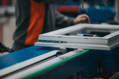 Midsection of manual worker making window frame at factory