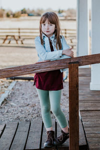 Portrait of girl standing on wood