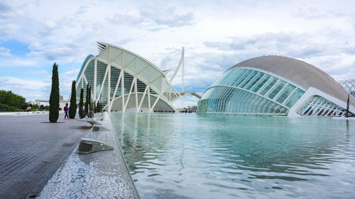 View of bridge in city against cloudy sky