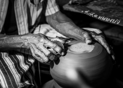 Midsection of man making pottery in workshop