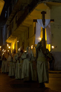 People holding illuminated street light at night