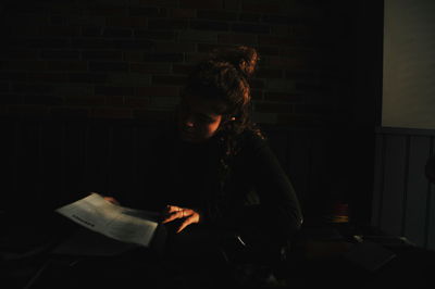 Side view of young woman sitting on book