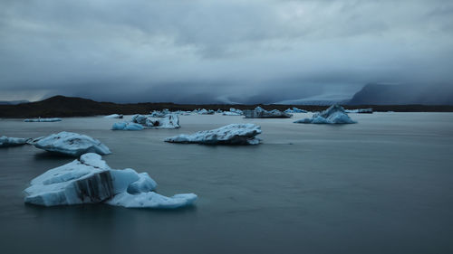 Frozen lake against sky during winter