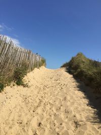 Scenic view of beach against clear blue sky