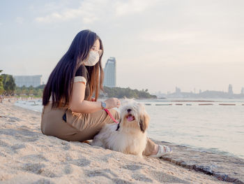 Side view of woman with dog on snow