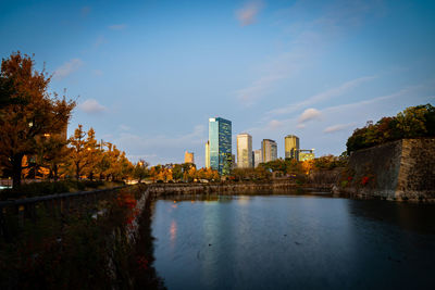 Scenic view of lake by buildings against sky