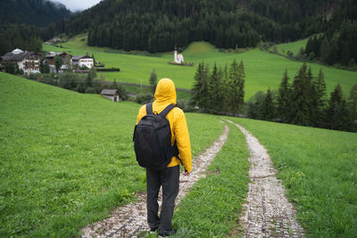 Rear view of woman walking on dirt road