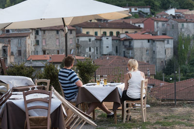 Rear view of couple sitting at outdoor restaurant
