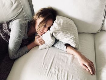 High angle view of woman lying on sofa