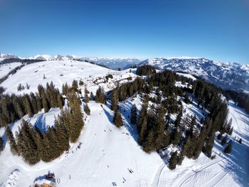 Scenic view of snowcapped mountains against clear blue sky