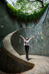 Full length of woman standing on wall