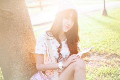 Midsection of woman sitting on mobile phone