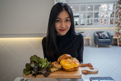 Portrait of woman with ice cream on table