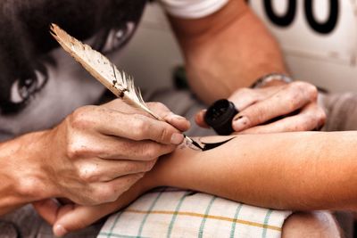 Close-up of person painting henna