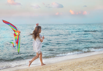 Woman standing on beach against sky