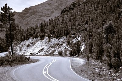 Empty road amidst trees and mountains