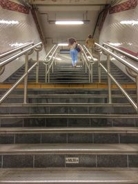 Woman standing on escalator