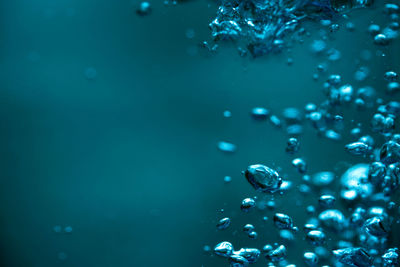 Close-up of bubbles against blue water