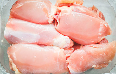 Raw boneless chicken thighs lie in a transparent plastic package