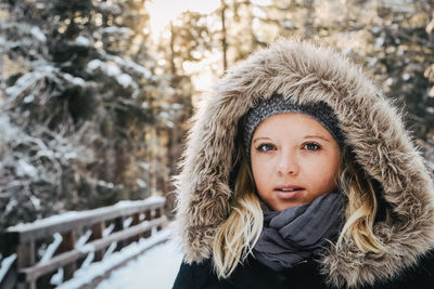 Portrait of young woman in forest during winter