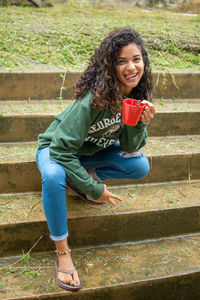 Portrait of smiling woman sitting on staircase