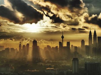 View of cityscape against cloudy sky during sunset