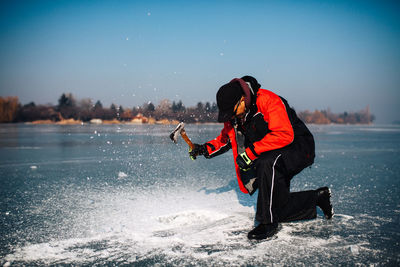 Man with axe on lake 