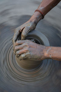 High angle view of wet hand in mud