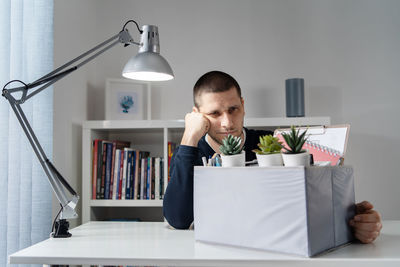 Young man reading book on table