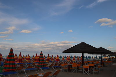 Chairs and tables against sky at sunset