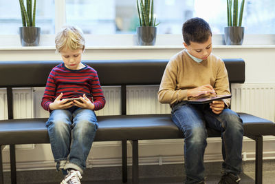 Boys using technologies while waiting at orthopedic clinic