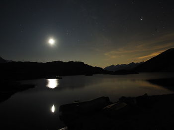 Scenic view of lake against sky at night