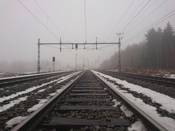 Railroad tracks against sky during winter