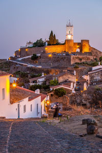 Illuminated buildings in city against sky