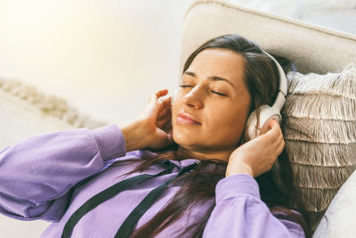 Woman lying on the couch listening to affirmations for the day