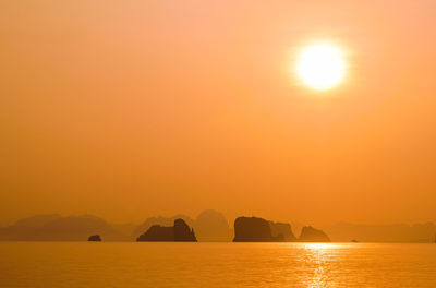 Orange sunrise on sugarload rock formations, over the sea in ko phang nga island, southern thailand