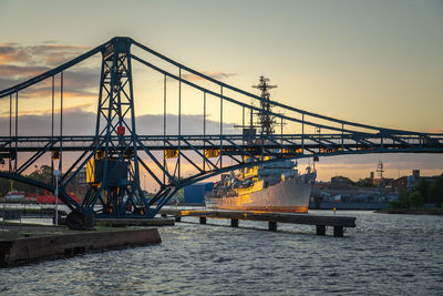 Bridge over river against sky during sunset