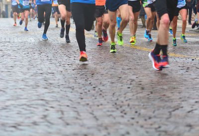 Low section of people running on street