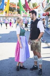 Smiling man and woman standing on street at event