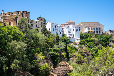 Low angle view of trees and buildings against clear sky